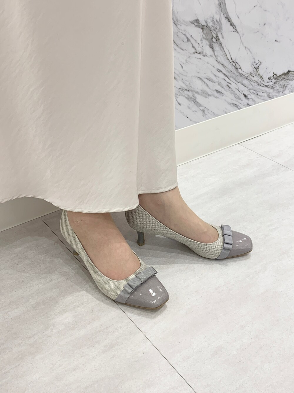 グレー系のパンプスを着用したレディースの春コーディネートの2枚目の写真