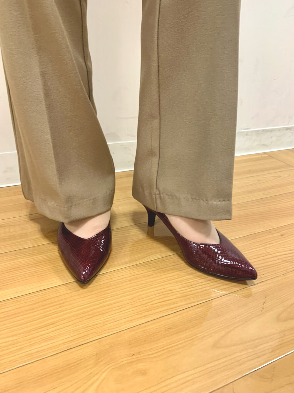 レッド系のパンプスを着用したレディースの秋コーディネートの2枚目の写真