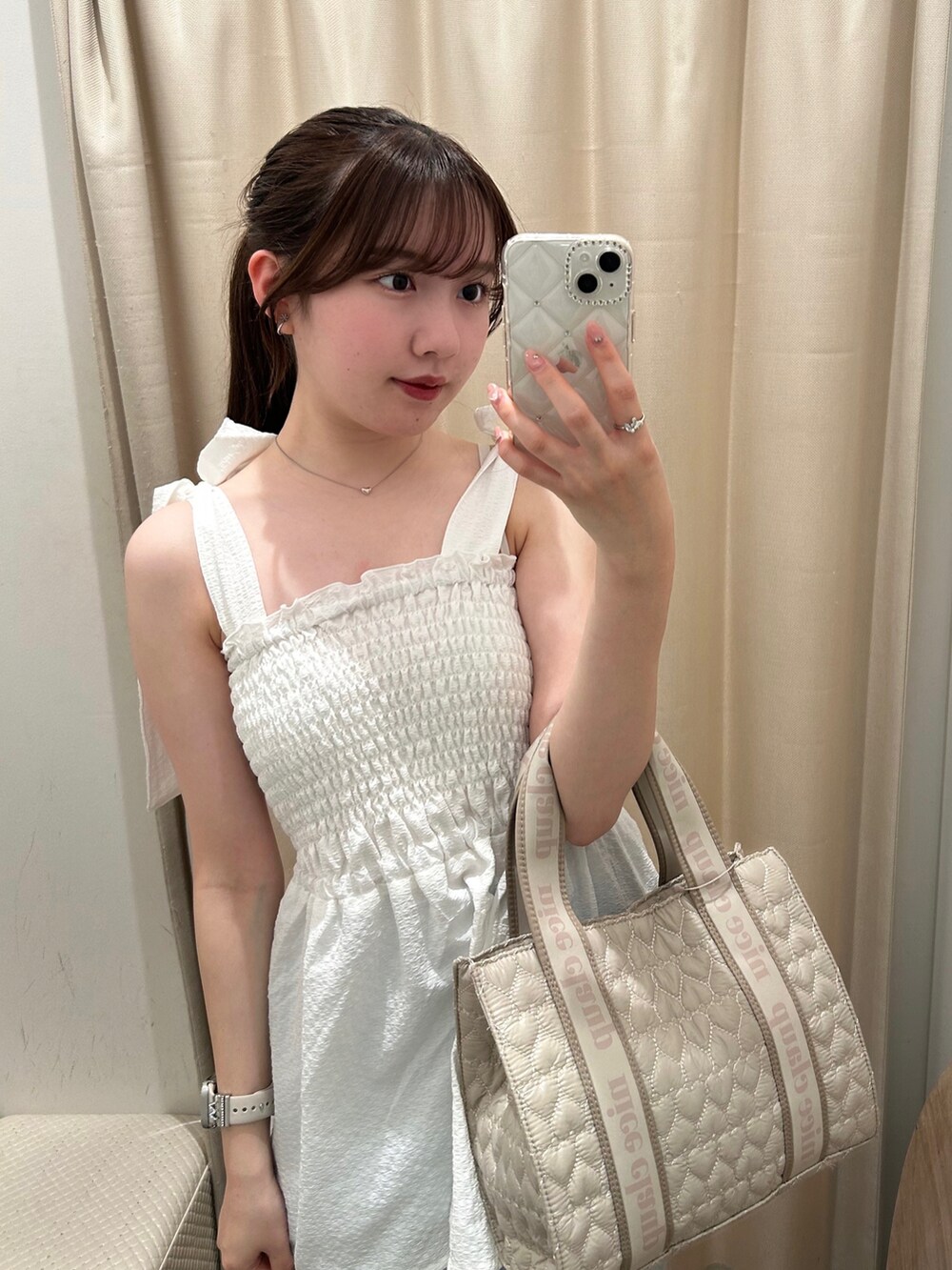 ベージュ系のショルダーバッグ、ホワイト系のキャミソール、ブルー系のデニムパンツを着用したレディースの夏コーディネートの4枚目の写真