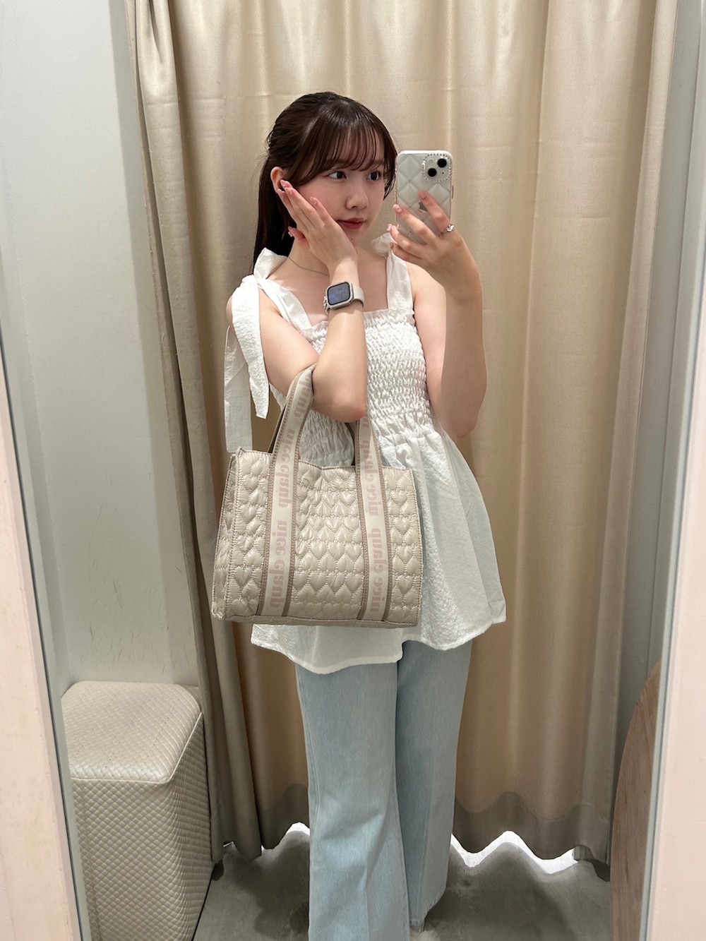 ベージュ系のショルダーバッグ、ホワイト系のキャミソール、ブルー系のデニムパンツを着用したレディースの夏コーディネートの3枚目の写真