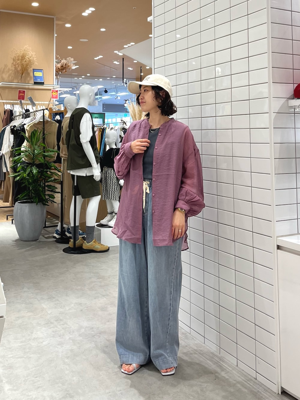 ブルー系のデニムパンツ、シルバー系のサンダル、グレー系のタンクトップを着用したレディースの春コーディネートの3枚目の写真