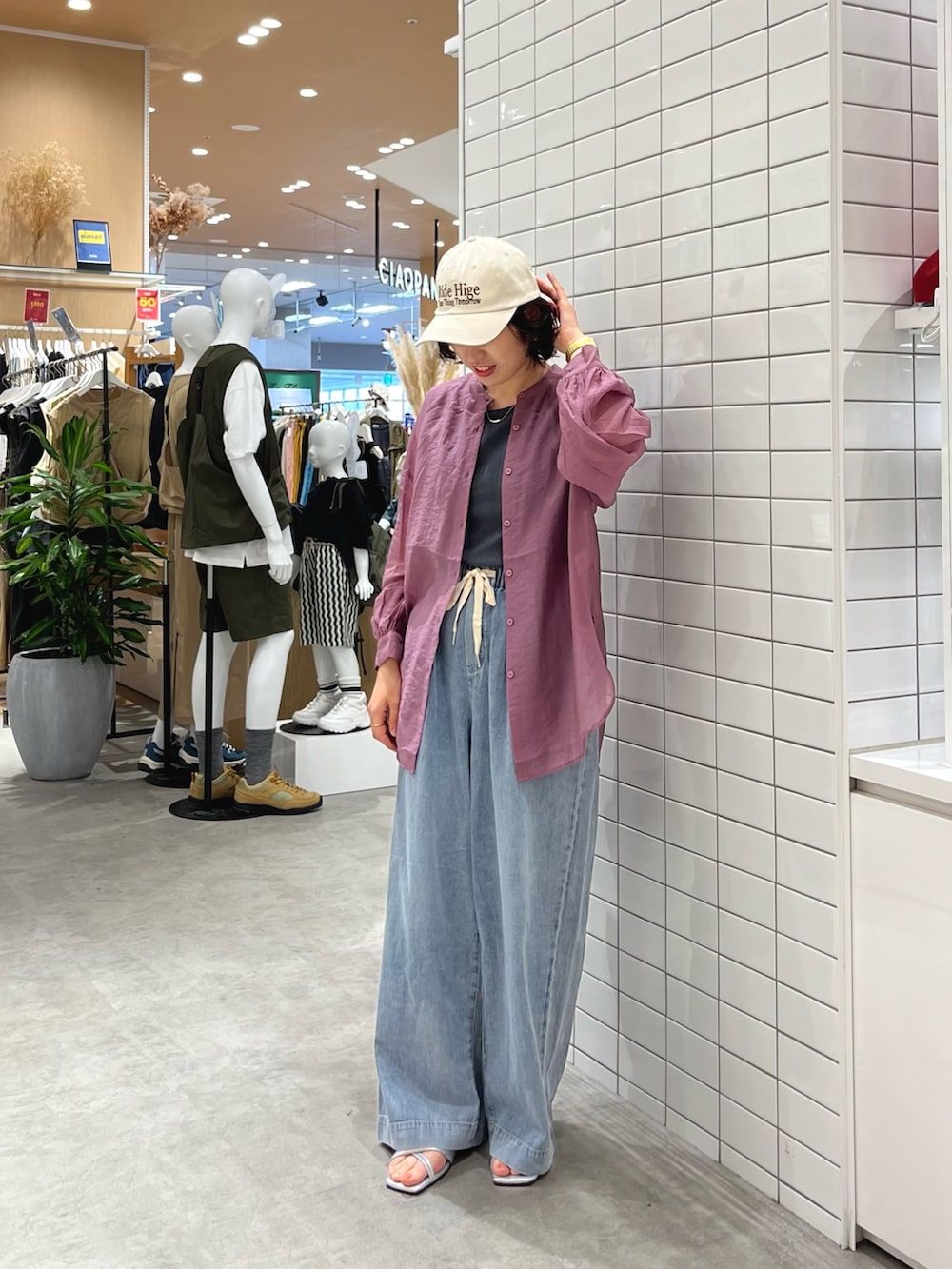 ブルー系のデニムパンツ、シルバー系のサンダル、グレー系のタンクトップを着用したレディースの春コーディネートの2枚目の写真