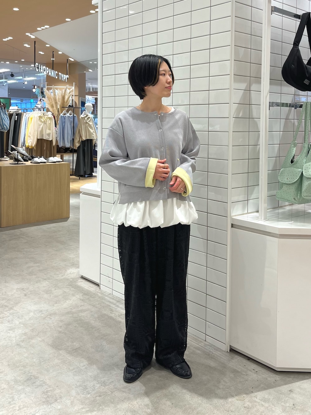 ホワイト系のTシャツ/カットソー、グレー系のカーディガン/ボレロ、ブラック系のその他パンツを着用したレディースの春コーディネートの2枚目の写真