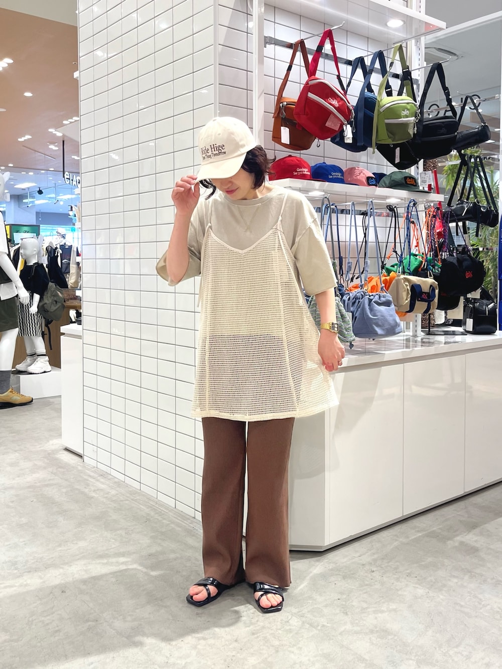 ブラック系のサンダル、ホワイト系のキャミソール、ブラウン系のその他パンツを着用したレディースの春コーディネートの2枚目の写真