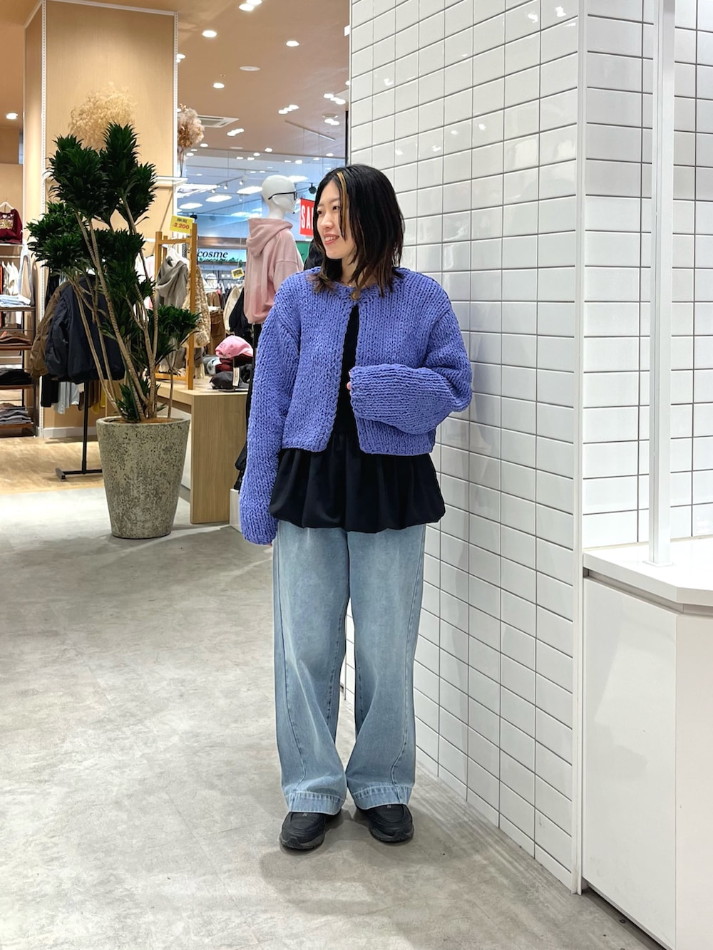 パープル系のカーディガン/ボレロ、ブラック系のTシャツ/カットソー、ブルー系のデニムパンツを着用したレディースの冬コーディネートの3枚目の写真