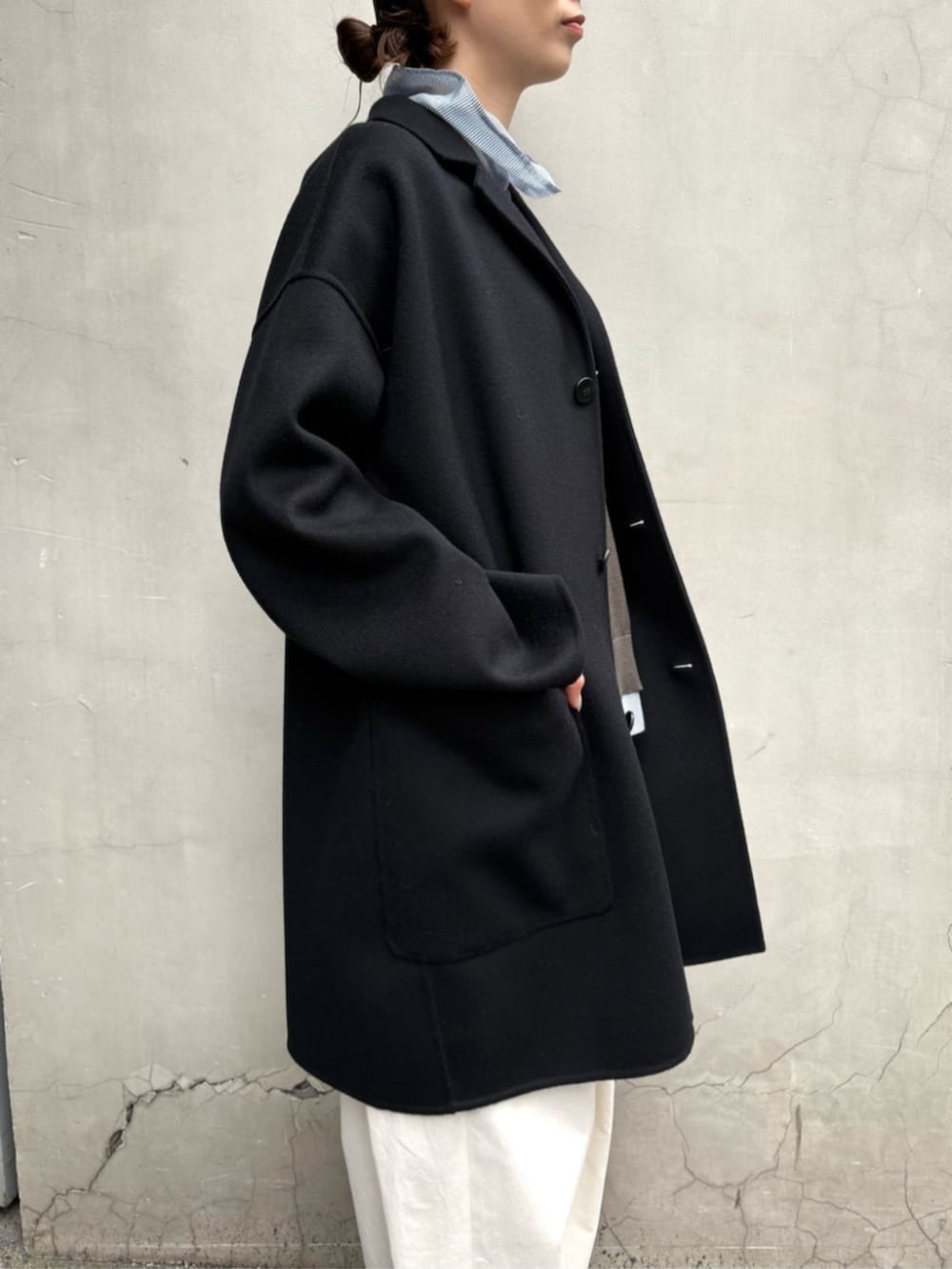 グレー系のニット/セーター、ブルー系のシャツ/ブラウス、ホワイト系のその他パンツを着用したレディースの冬コーディネートの2枚目の写真