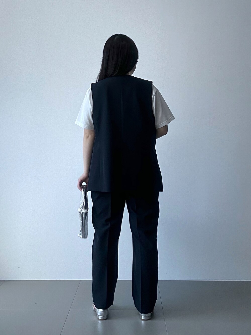 ブルー系のベスト、ブルー系のスラックス、シルバー系のバッグを着用したレディースの春コーディネートの3枚目の写真