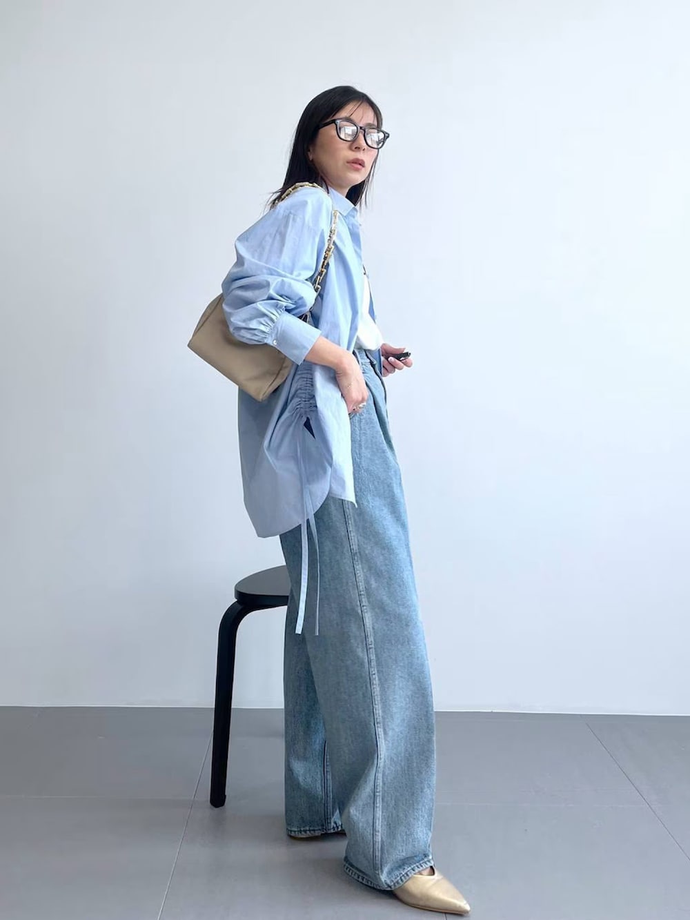 ブルー系のシャツ/ブラウス、ホワイト系のTシャツ/カットソー、ブルー系のデニムパンツを着用したレディースの春コーディネートの2枚目の写真