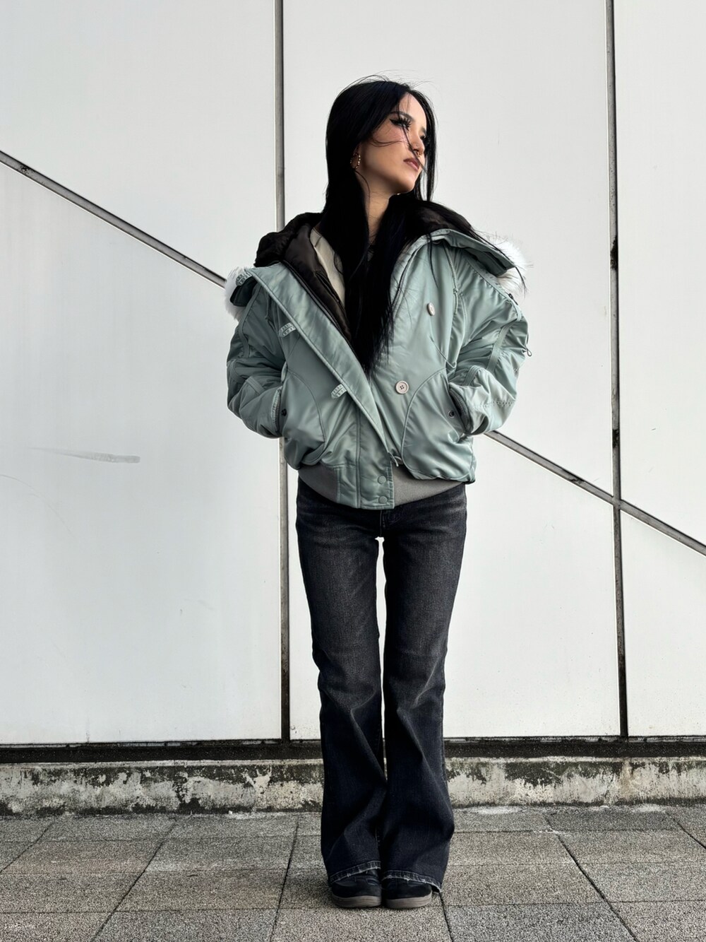 ベージュ系のTシャツ/カットソー、ブラック系のデニムパンツ、グリーン系のミリタリージャケットを着用したレディースの秋コーディネートの2枚目の写真