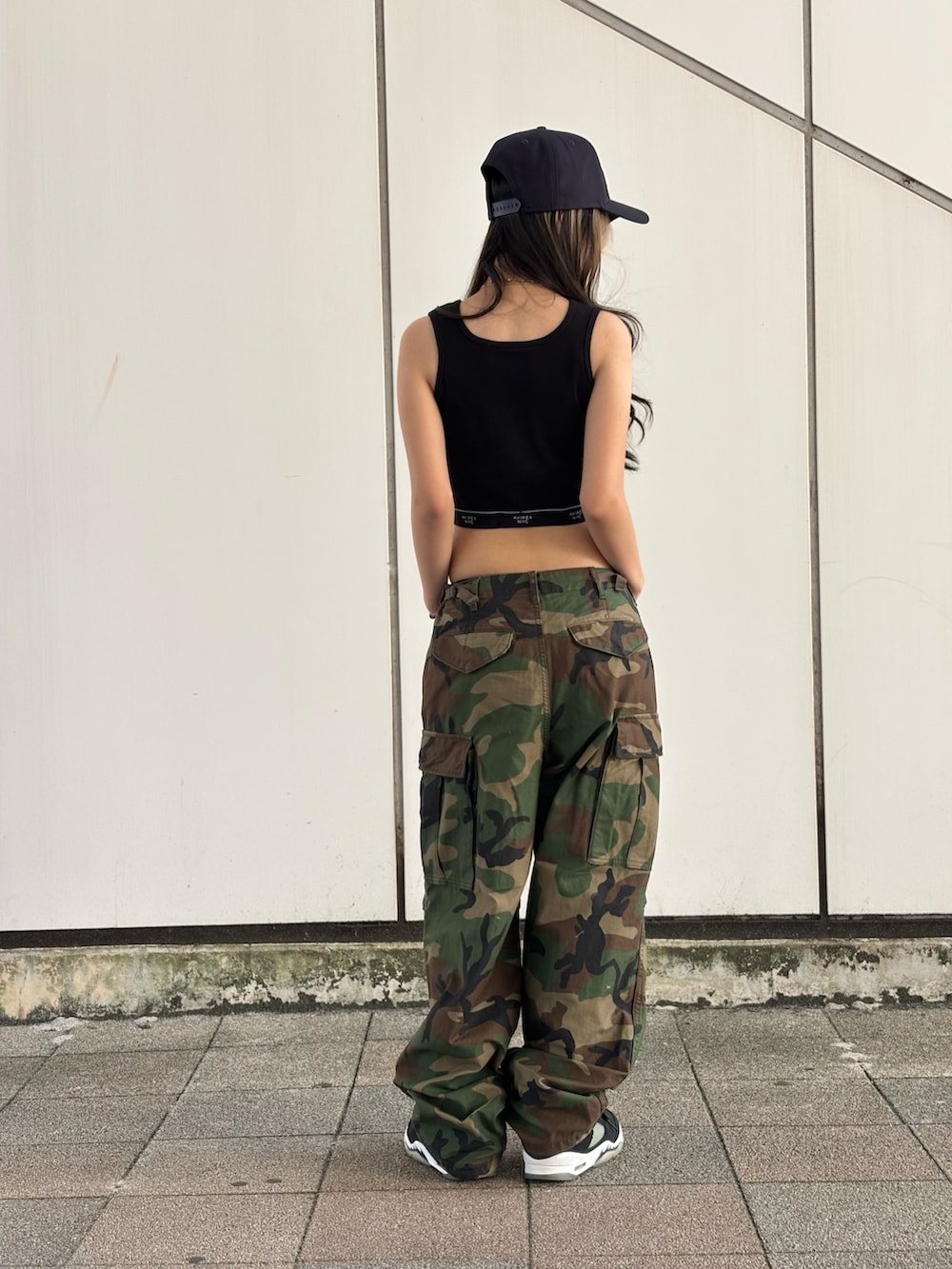 ブラック系のタンクトップ、その他のカーゴパンツ、ブラック系のキャップを着用したレディースの夏コーディネートの2枚目の写真