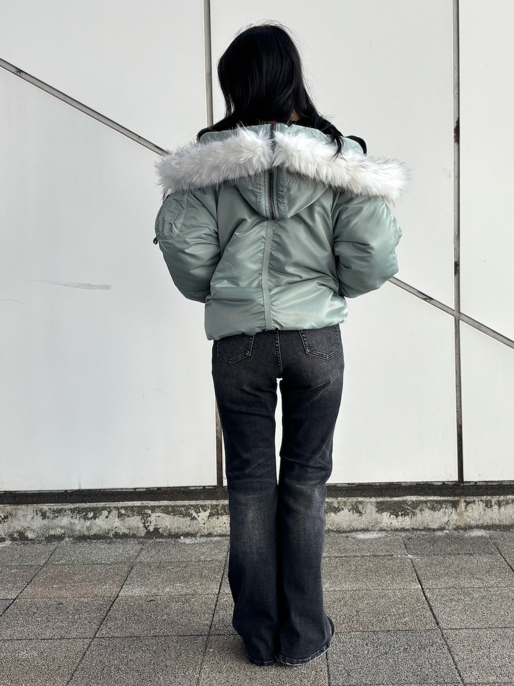 ベージュ系のTシャツ/カットソー、ブラック系のデニムパンツ、グリーン系のミリタリージャケットを着用したレディースの秋コーディネートの3枚目の写真