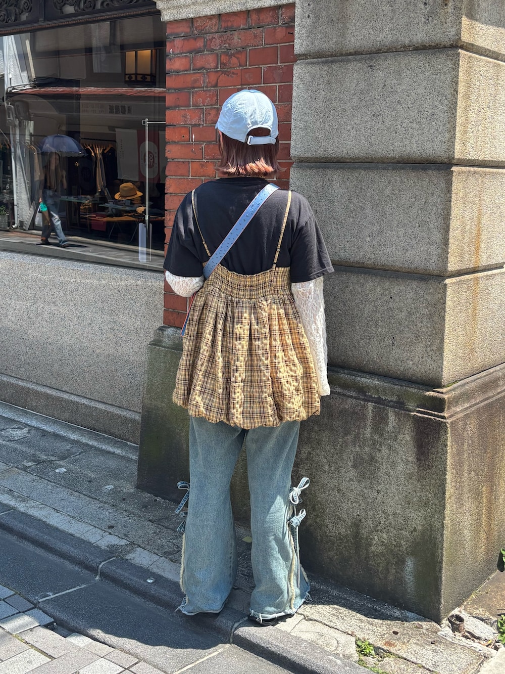 イエロー系のキャミソール、ベージュ系のデニムパンツ、ホワイト系のTシャツ/カットソーを着用したレディースの夏コーディネートの3枚目の写真