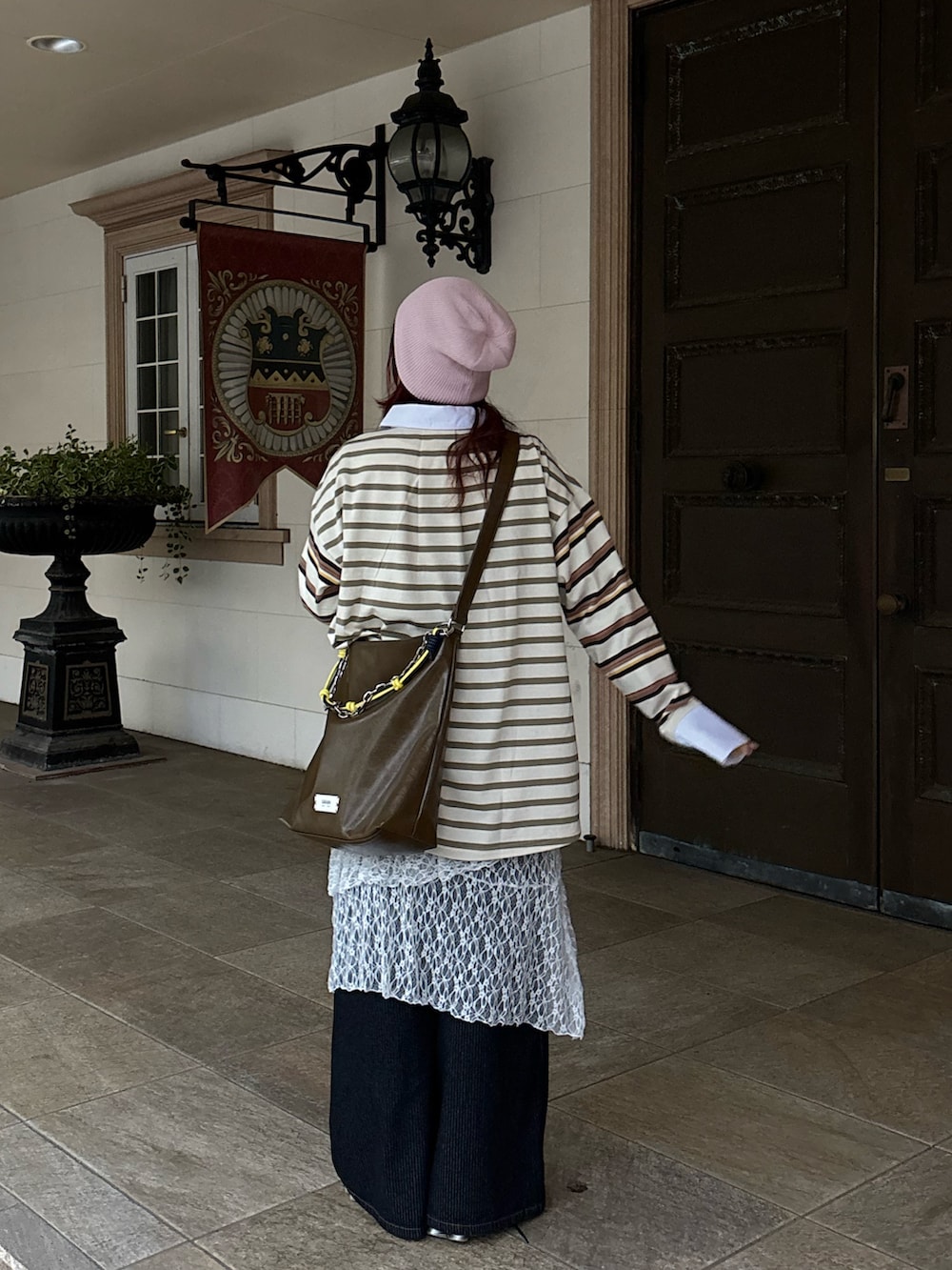 ベージュ系のTシャツ/カットソー、ホワイト系のスカート、グレー系のデニムパンツを着用したレディースの春コーディネートの2枚目の写真