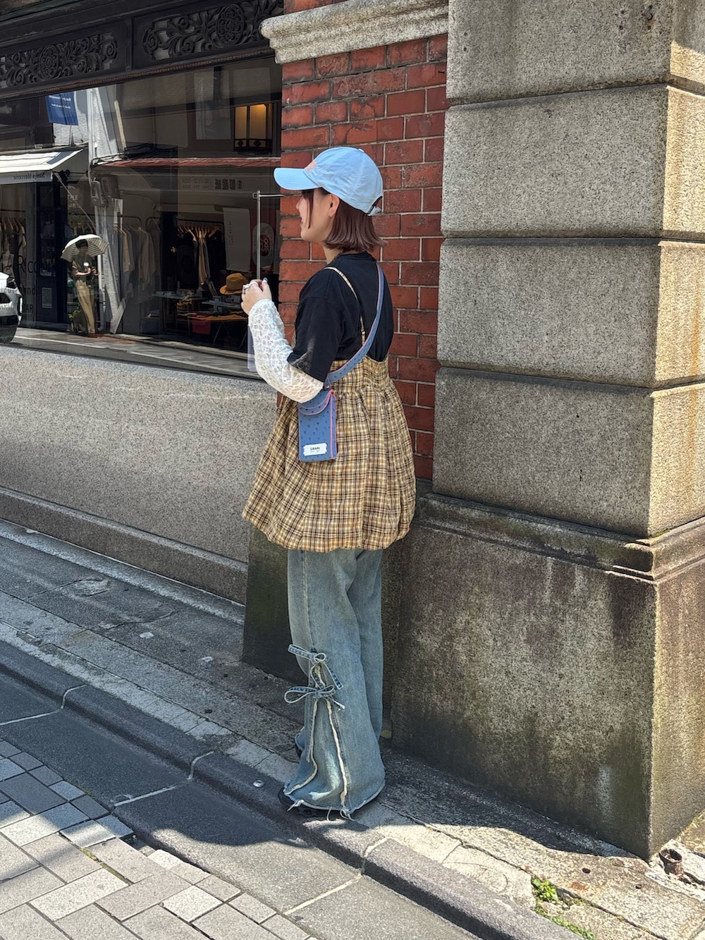 イエロー系のキャミソール、ベージュ系のデニムパンツ、ホワイト系のTシャツ/カットソーを着用したレディースの夏コーディネートの2枚目の写真