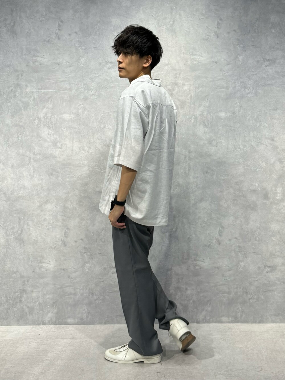 グレー系のスラックス、ホワイト系のシャツ/ブラウス、ブラック系のTシャツ/カットソーを着用したメンズの夏コーディネートの3枚目の写真