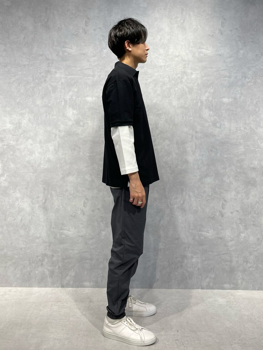 グレー系のスウェットパンツ、ブラック系のポロシャツ、ホワイト系のTシャツ/カットソーを着用したメンズの春コーディネートの2枚目の写真