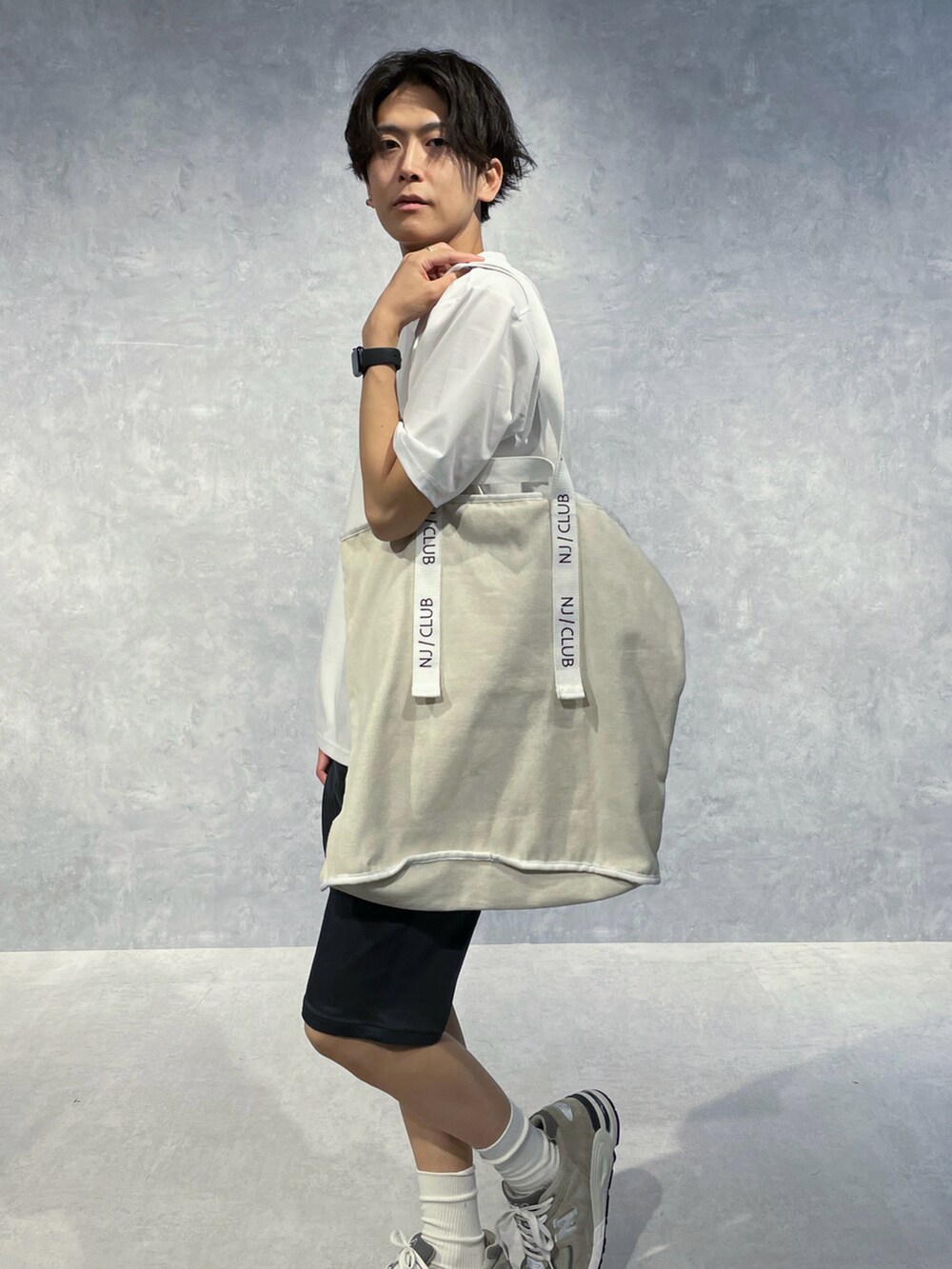 ホワイト系のトートバッグ、グレー系のその他パンツを着用したメンズの夏コーディネートの2枚目の写真