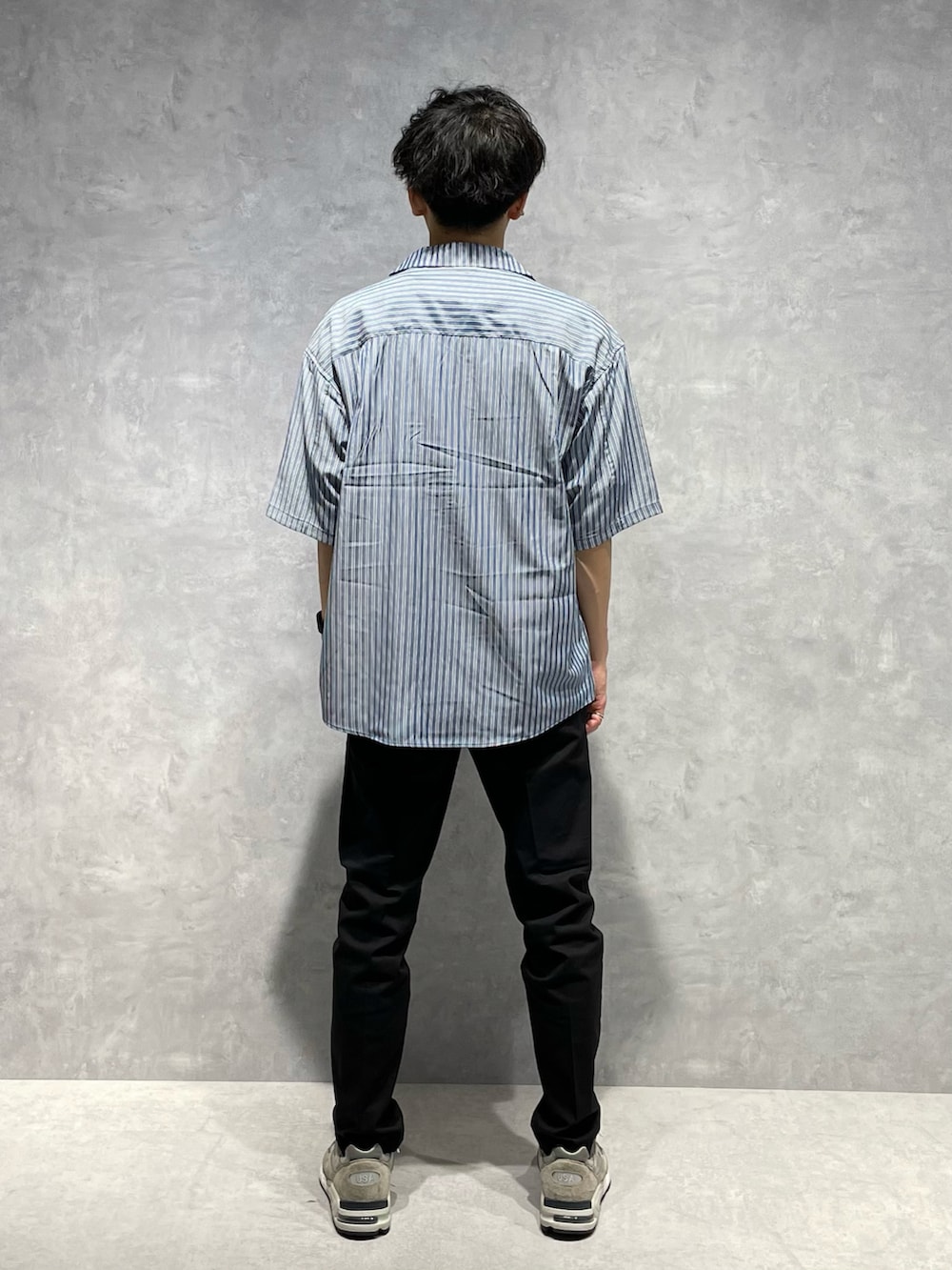 ブルー系のシャツ/ブラウス、ホワイト系のTシャツ/カットソー、ブラック系のスラックスを着用したメンズの春コーディネートの3枚目の写真