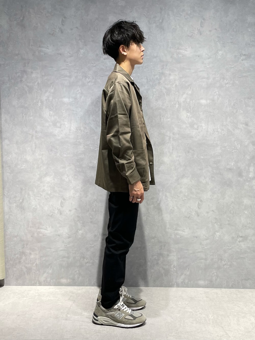 グリーン系のブルゾン、ホワイト系のTシャツ/カットソー、ブラック系のスラックスを着用したメンズの春コーディネートの2枚目の写真