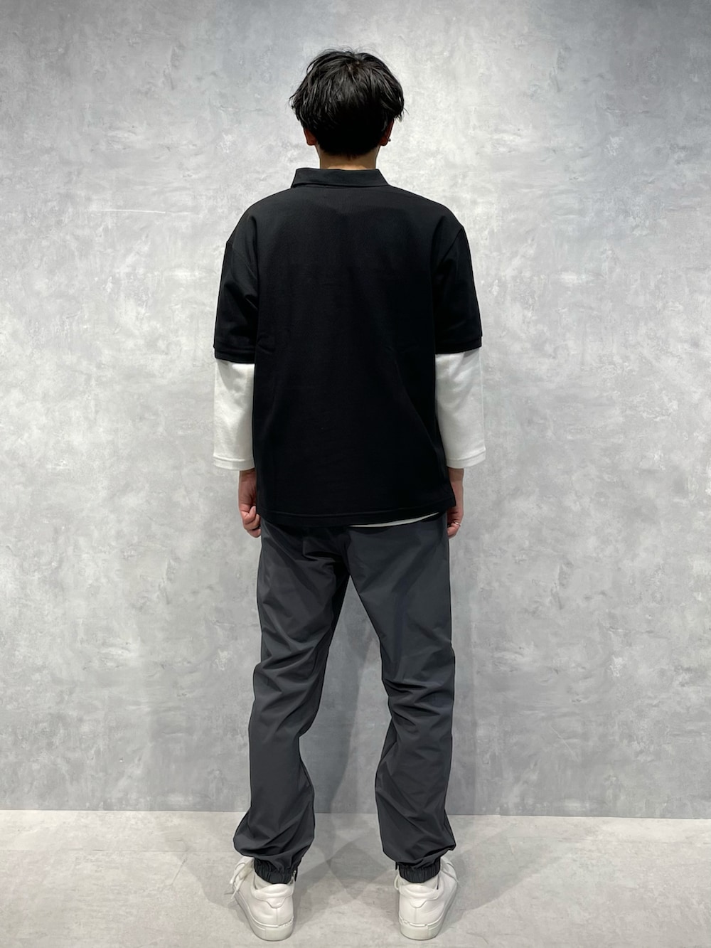 グレー系のスウェットパンツ、ブラック系のポロシャツ、ホワイト系のTシャツ/カットソーを着用したメンズの春コーディネートの3枚目の写真