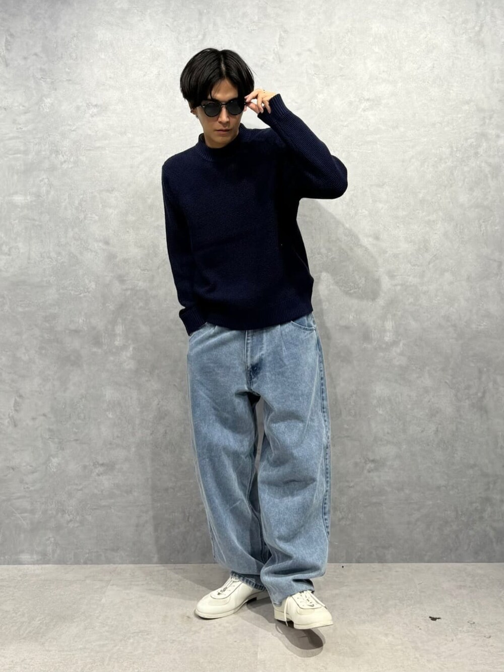 ブルー系のニット/セーター、ブラック系のショルダーバッグ、ブルー系のデニムパンツを着用したメンズの冬コーディネートの2枚目の写真