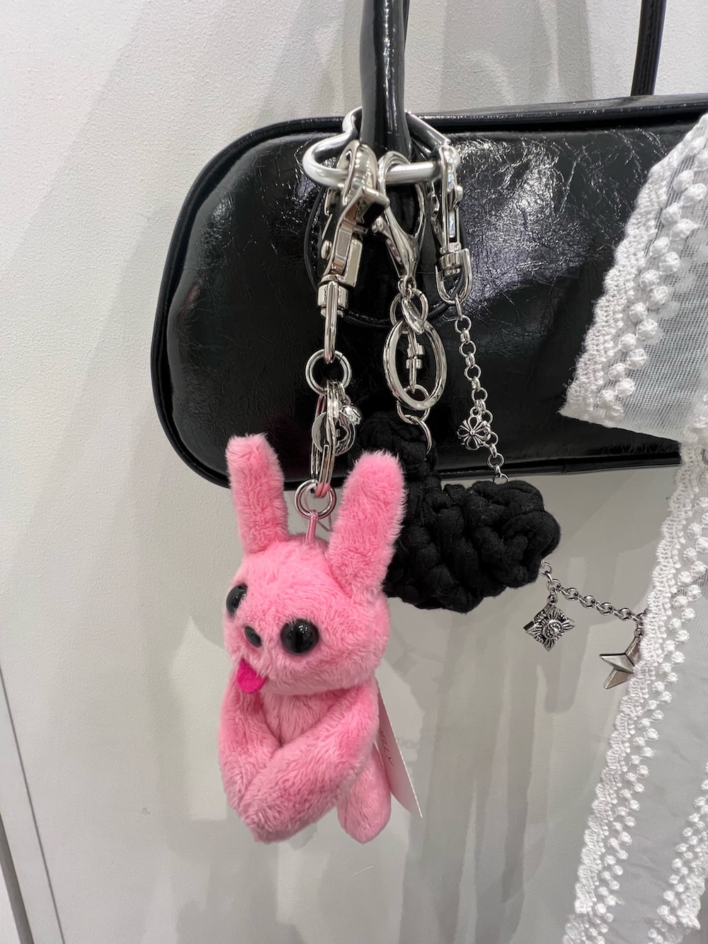 ホワイト系のネックレス、ブラック系のキーホルダー、ピンク系のキーホルダーを着用したレディースの冬コーディネートの2枚目の写真