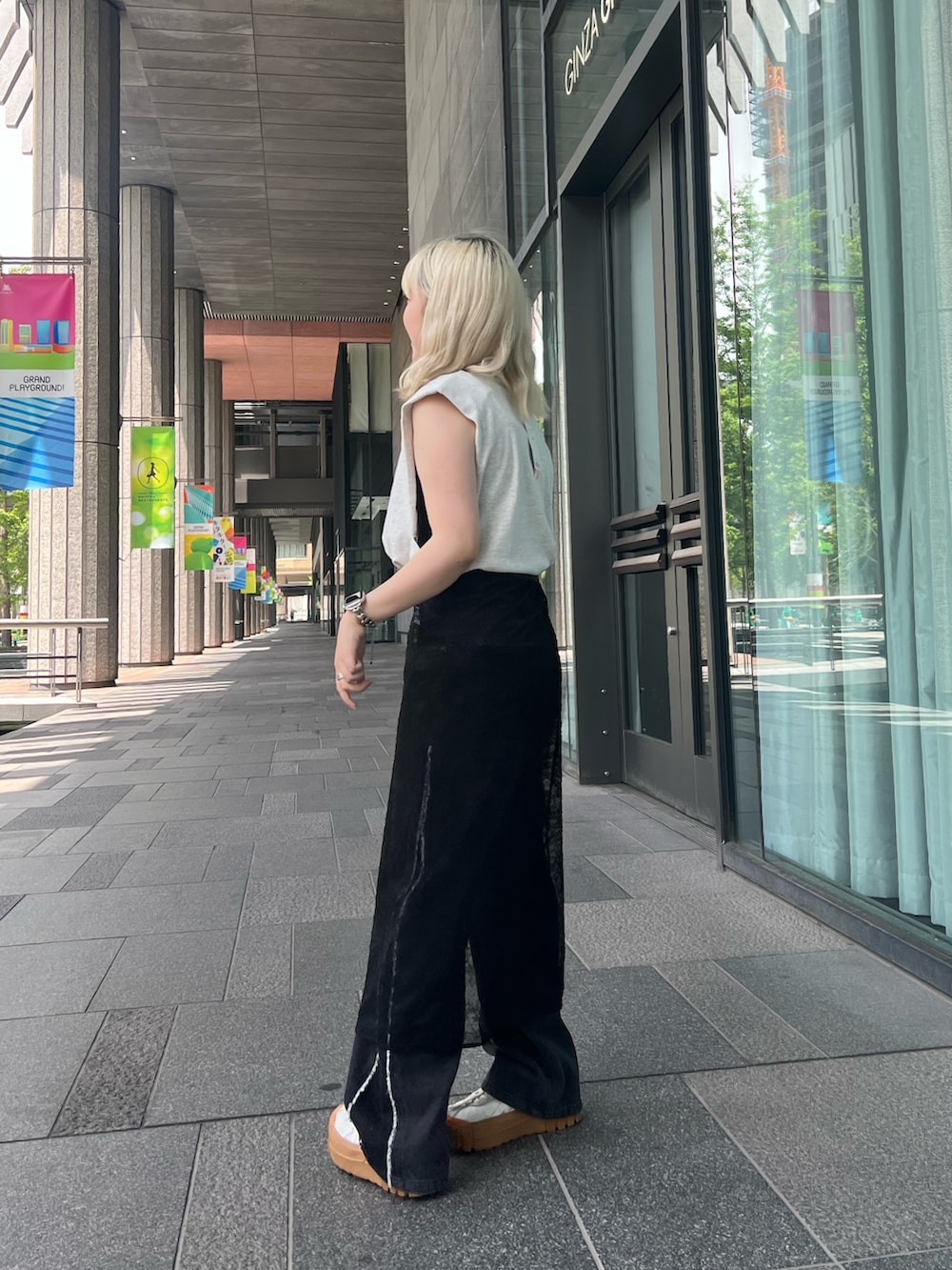 グレー系のTシャツ/カットソー、ブラック系のスカート、ブラック系のデニムパンツを着用したレディースの夏コーディネートの2枚目の写真