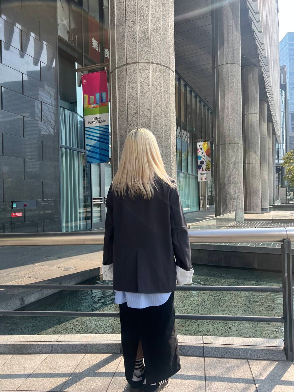 ブラック系のスカート、グレー系のテーラードジャケット、ブルー系のシャツ/ブラウスを着用したレディースの冬コーディネートの2枚目の写真