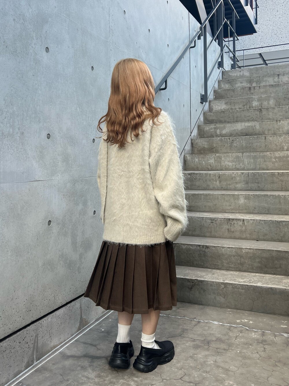 ベージュ系のカーディガン/ボレロ、ブラウン系のスカート、ブラック系のローファーを着用したレディースの秋コーディネートの2枚目の写真