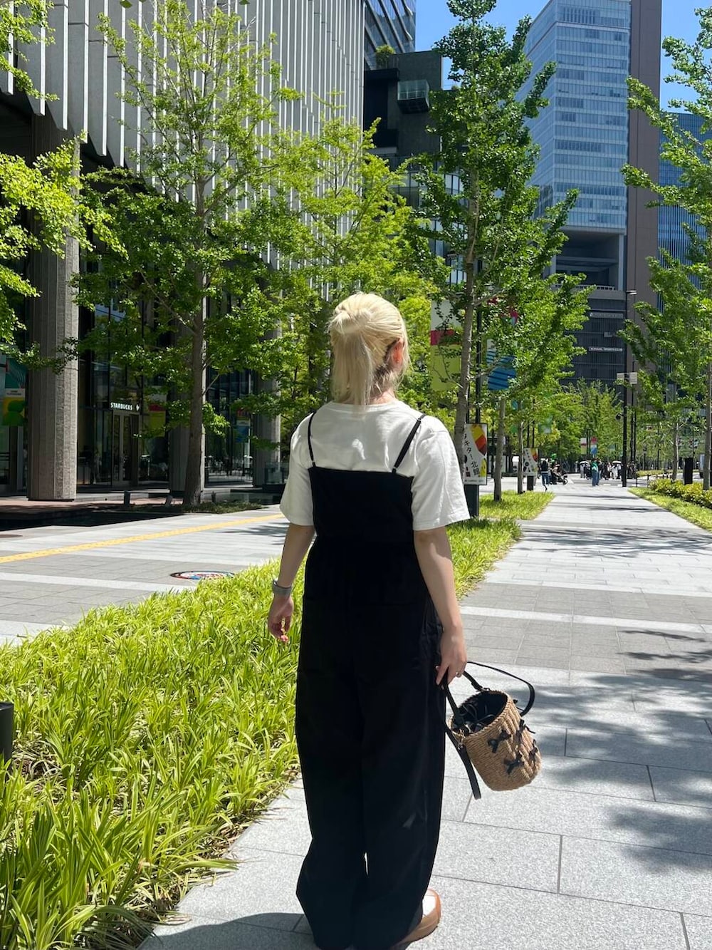 イエロー系のショルダーバッグ、その他のTシャツ/カットソー、ブラック系のサロペット/オーバーオールを着用したレディースの春コーディネートの2枚目の写真