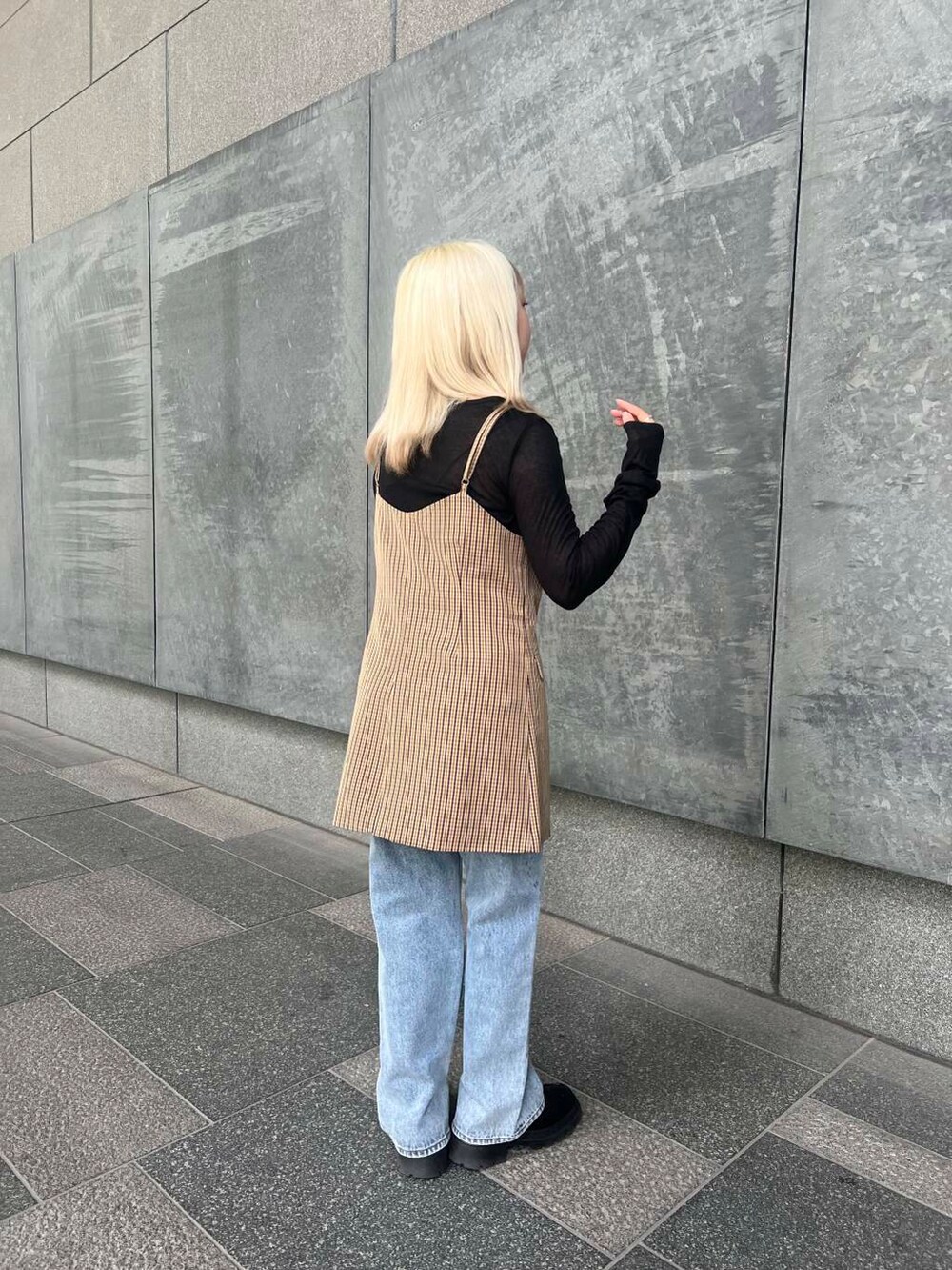 ブルー系のデニムパンツ、ブラウン系のチュニック、ブラック系のTシャツ/カットソーを着用したレディースの秋コーディネートの2枚目の写真