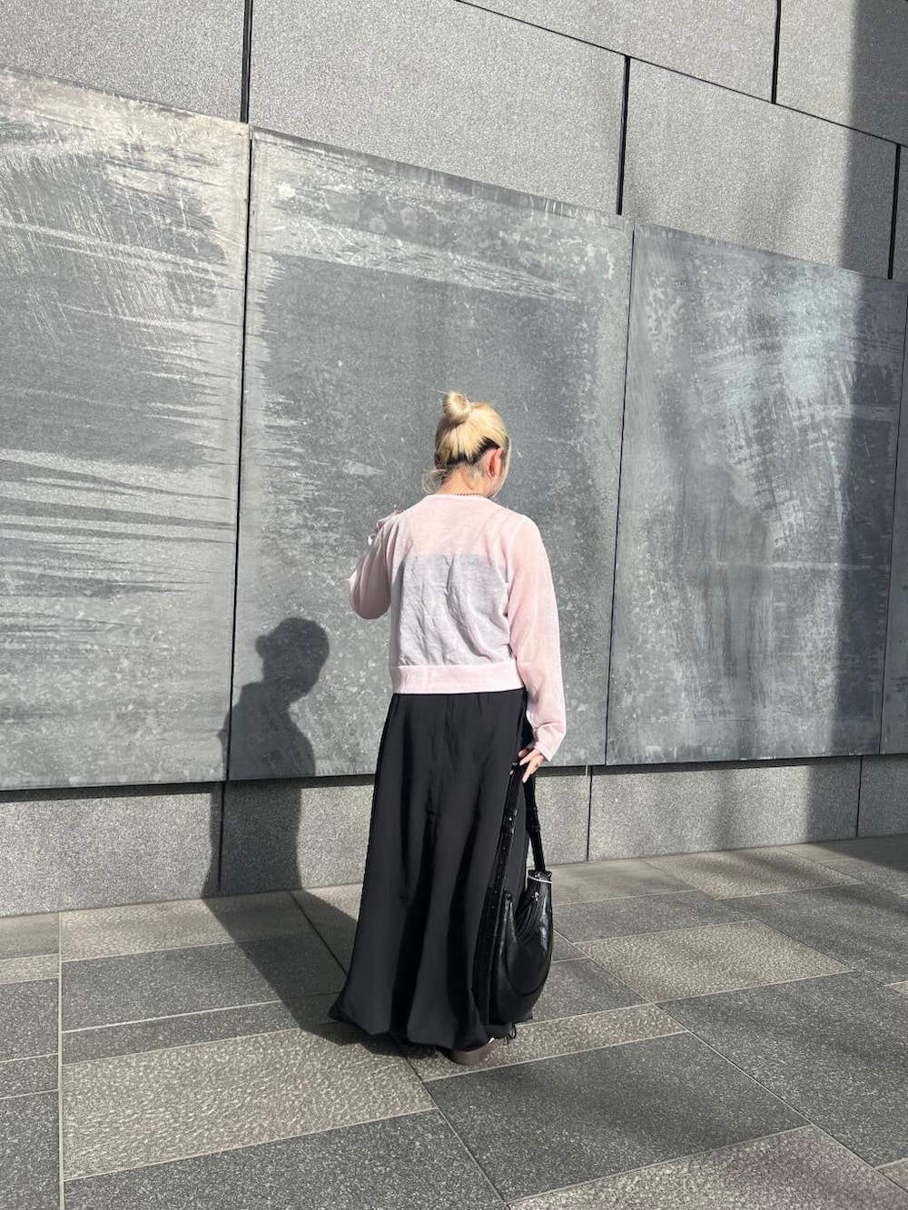 ブラック系のスカート、ブラック系のショルダーバッグ、ブラック系のキャミソールを着用したレディースの春コーディネートの2枚目の写真