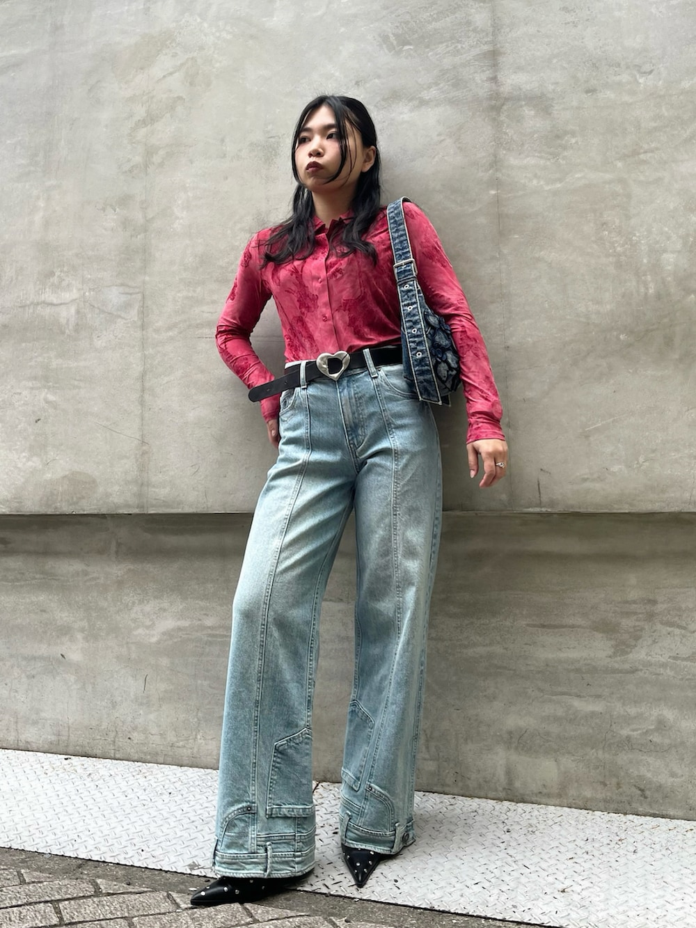 レッド系のTシャツ/カットソー、ブルー系のデニムパンツ、ブルー系のハンドバッグを着用したレディースの冬コーディネートの2枚目の写真