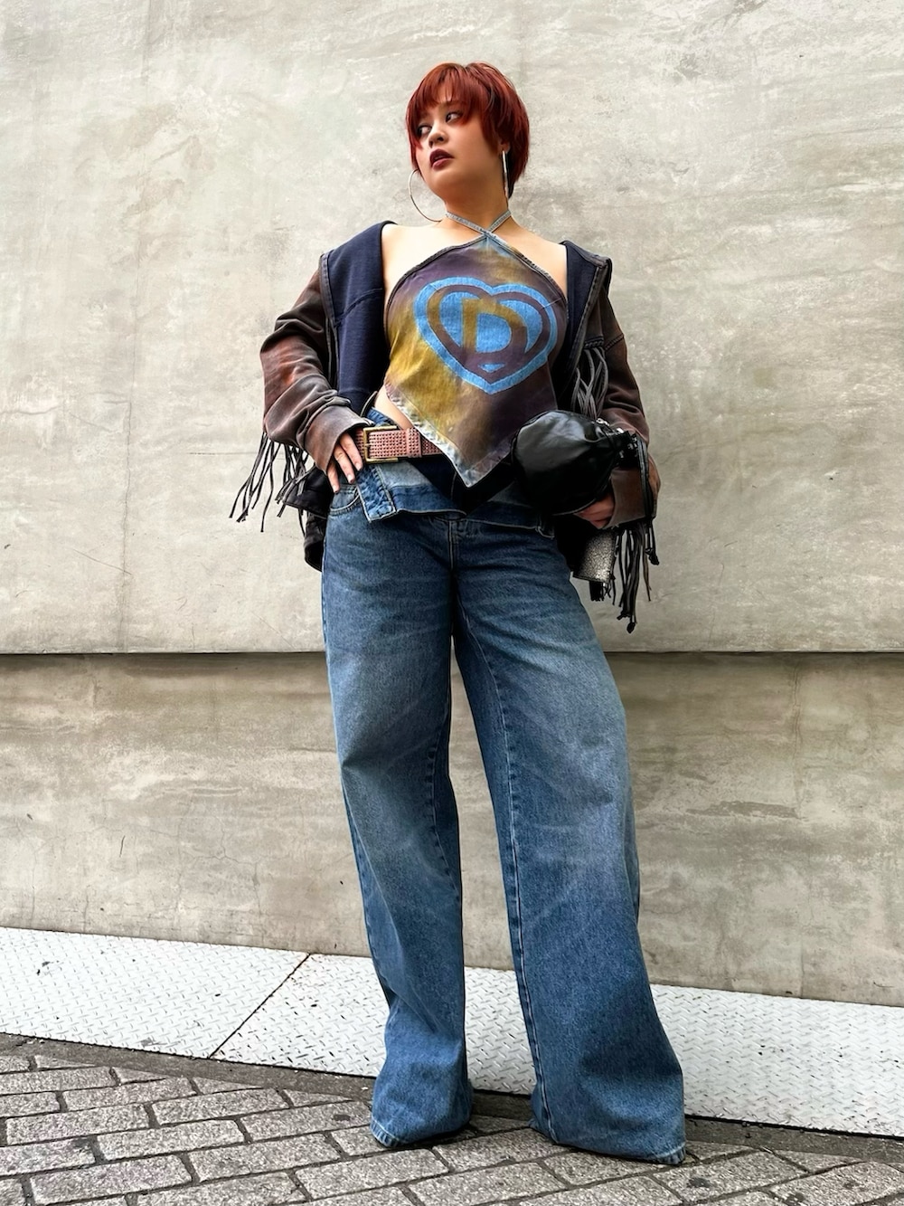 ブラック系のバッグ、ブルー系のデニムパンツ、イエロー系のチューブトップを着用したレディースの春コーディネートの2枚目の写真