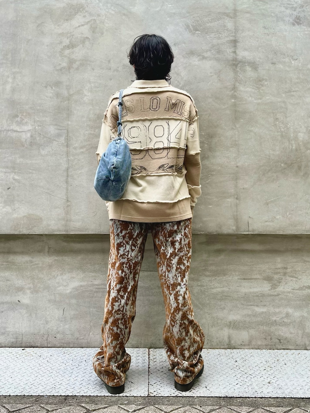 ブルー系のショルダーバッグ、ブラウン系のトップス、ブルー系のデニムパンツを着用したメンズの冬コーディネートの2枚目の写真