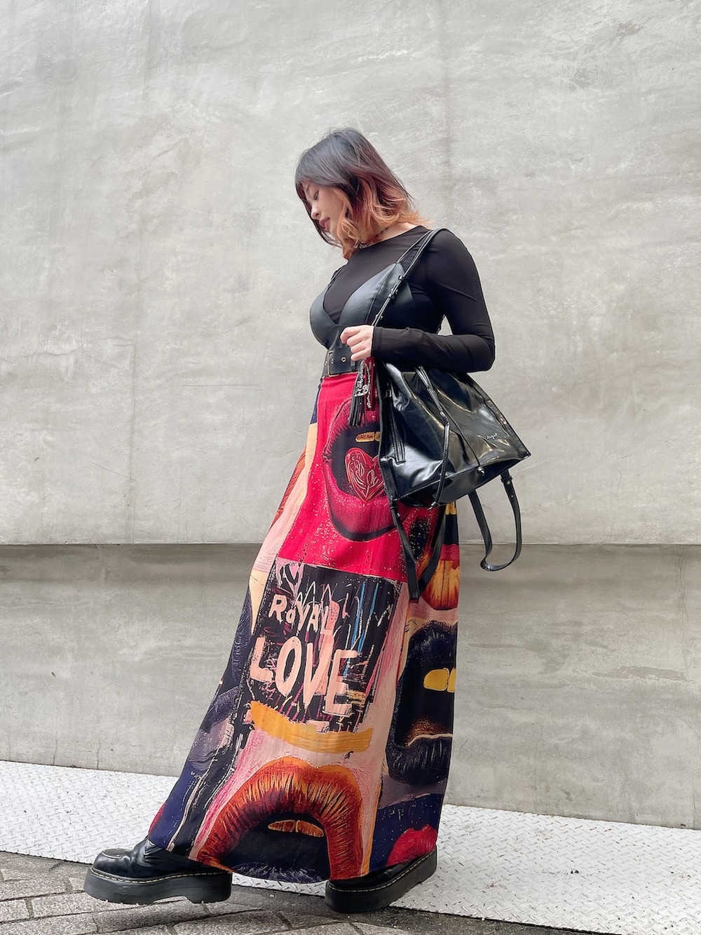 ブラック系のワンピース、ブラック系のバックパック/リュック、ブラック系のブーツを着用したレディースの冬コーディネートの2枚目の写真