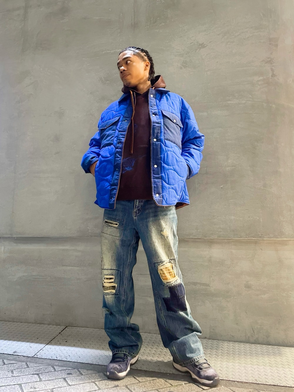 ブルー系のブルゾン、ブルー系のデニムパンツ、ブラウン系のパーカーを着用したメンズの秋コーディネートの2枚目の写真