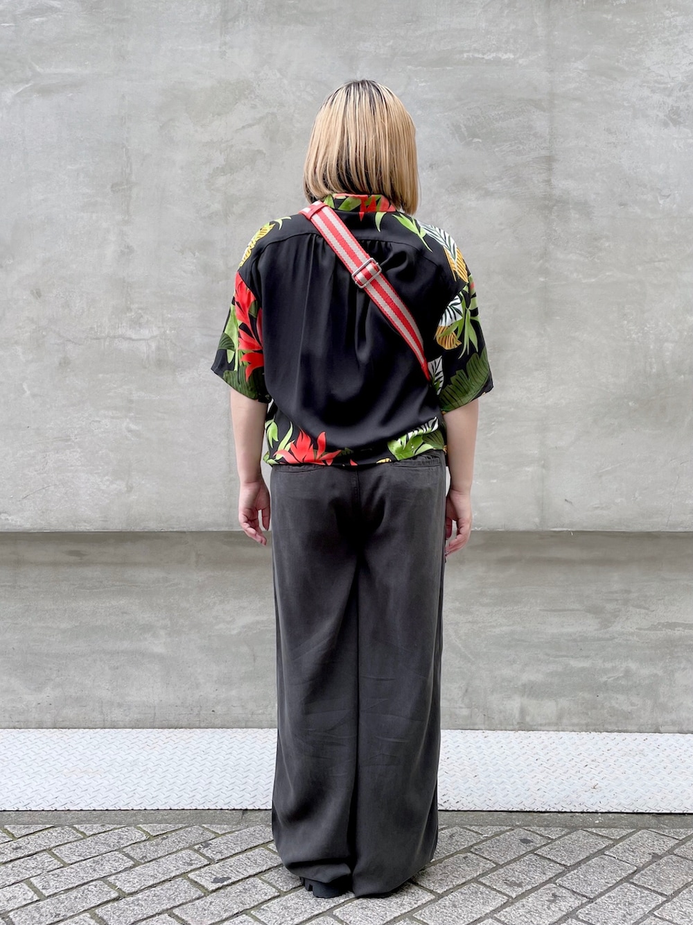 ブラック系のシャツ/ブラウス、ブラック系のカーゴパンツ、オレンジ系のボディバッグ/ウエストポーチを着用したレディースの春コーディネートの2枚目の写真