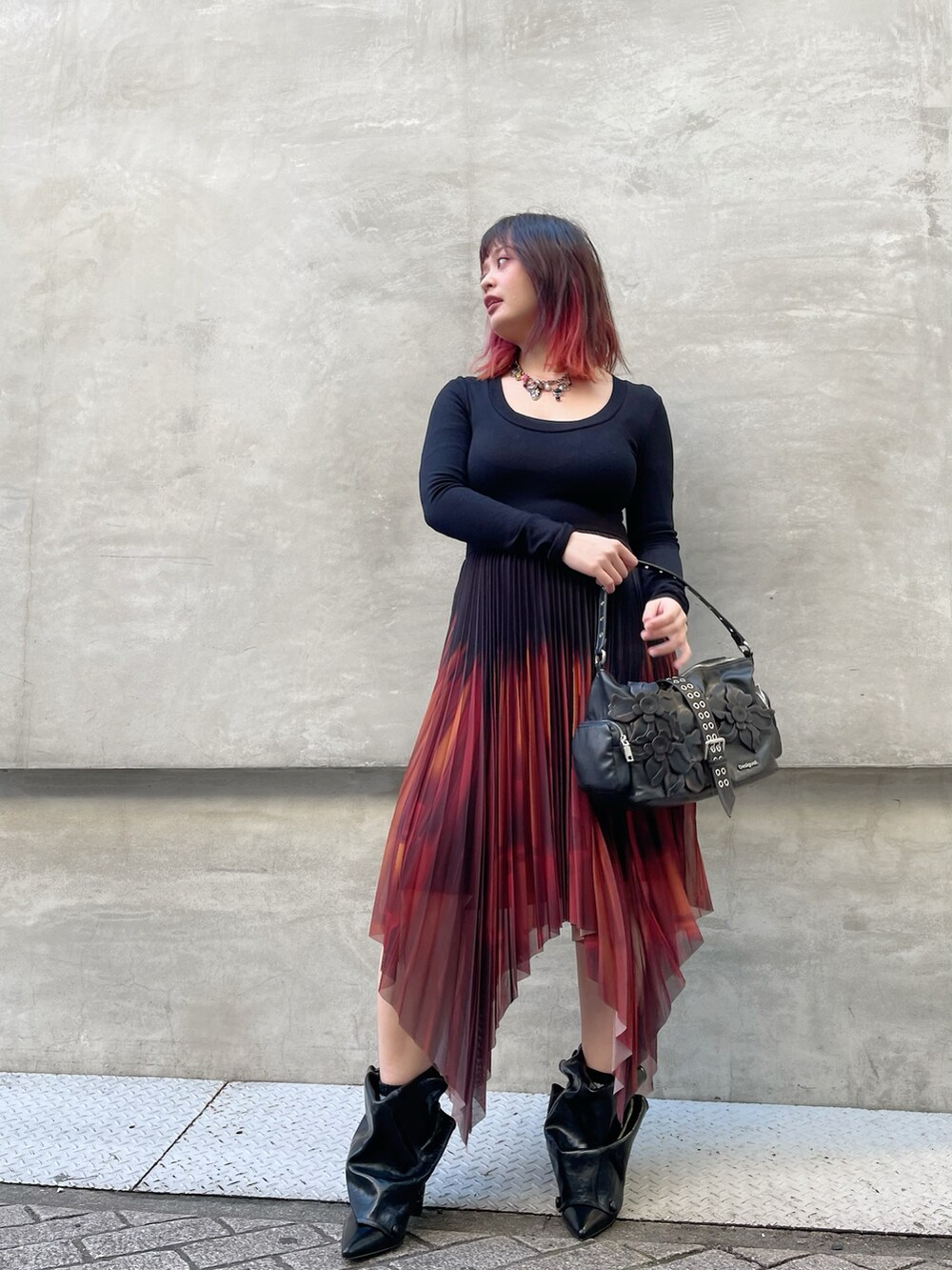 ブラウン系のハンドバッグ、ブラック系のブーツ、ブラック系のワンピースを着用したレディースの冬コーディネートの2枚目の写真