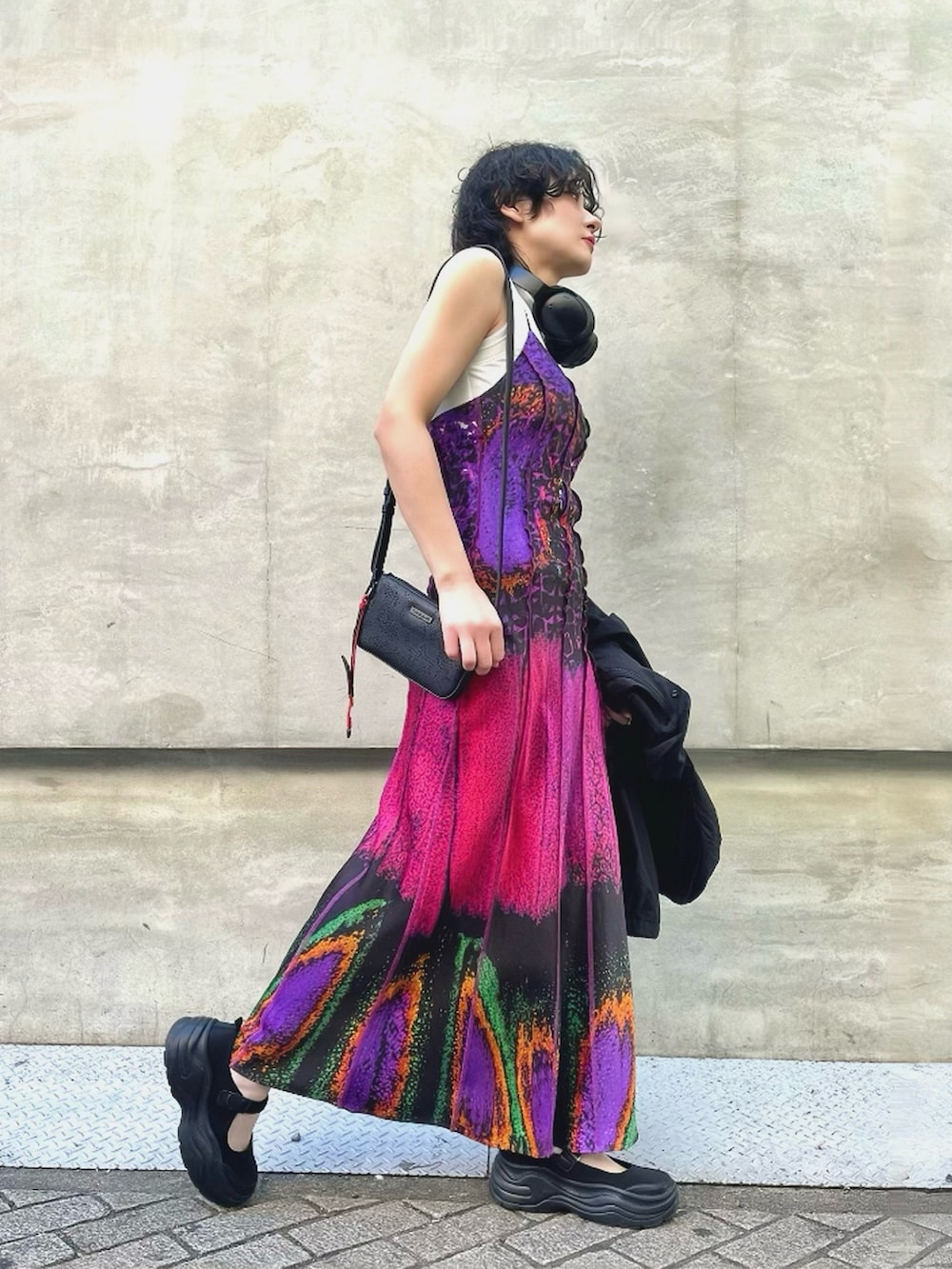 レッド系のワンピース、ブラック系のショルダーバッグ、ブラック系のジャケット/アウターを着用したレディースの冬コーディネートの2枚目の写真