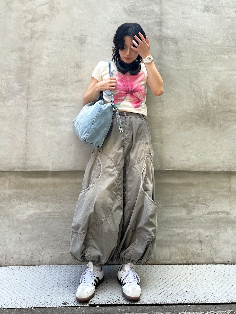 ブルー系のショルダーバッグ、ホワイト系のTシャツ/カットソー、グリーン系のパンツを着用したレディースの夏コーディネートの2枚目の写真