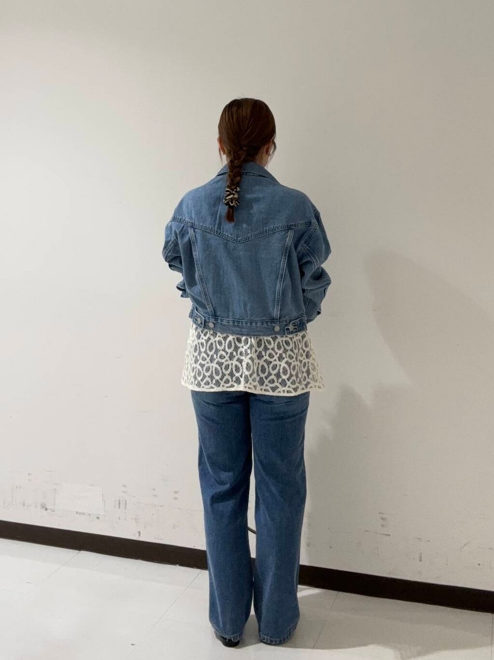 グリーン系のハンドバッグ、ブラック系のその他シューズ、ブルー系のデニムパンツを着用したレディースの夏コーディネートの3枚目の写真