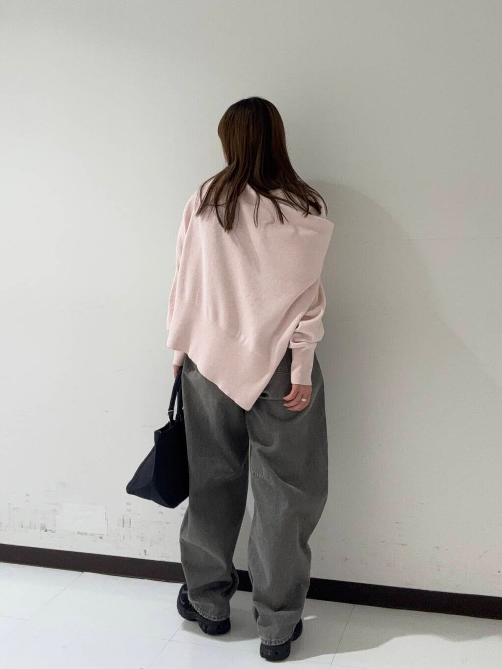 グリーン系のデニムパンツ、ベージュ系のトレンチコート、ブラック系のショルダーバッグを着用したレディースの冬コーディネートの4枚目の写真