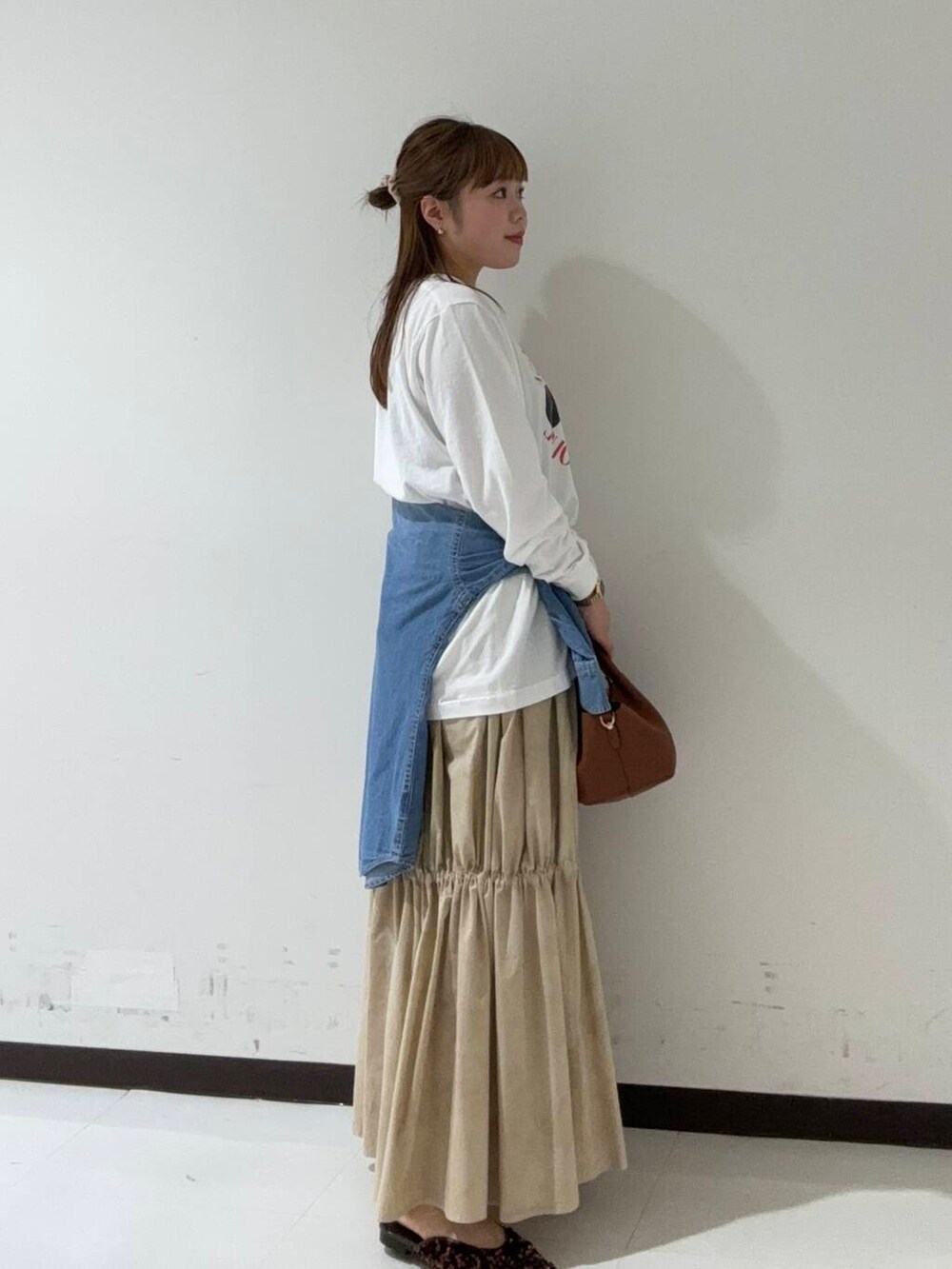 ブラウン系のその他シューズ、ブルー系のTシャツ/カットソー、ブラウン系のショルダーバッグを着用したレディースの秋コーディネートの3枚目の写真