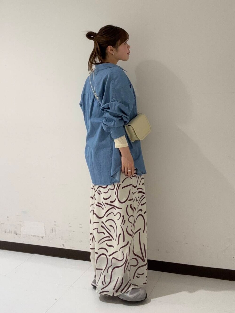 イエロー系のTシャツ/カットソー、ホワイト系のショルダーバッグ、レッド系のワンピースを着用したレディースの冬コーディネートの2枚目の写真