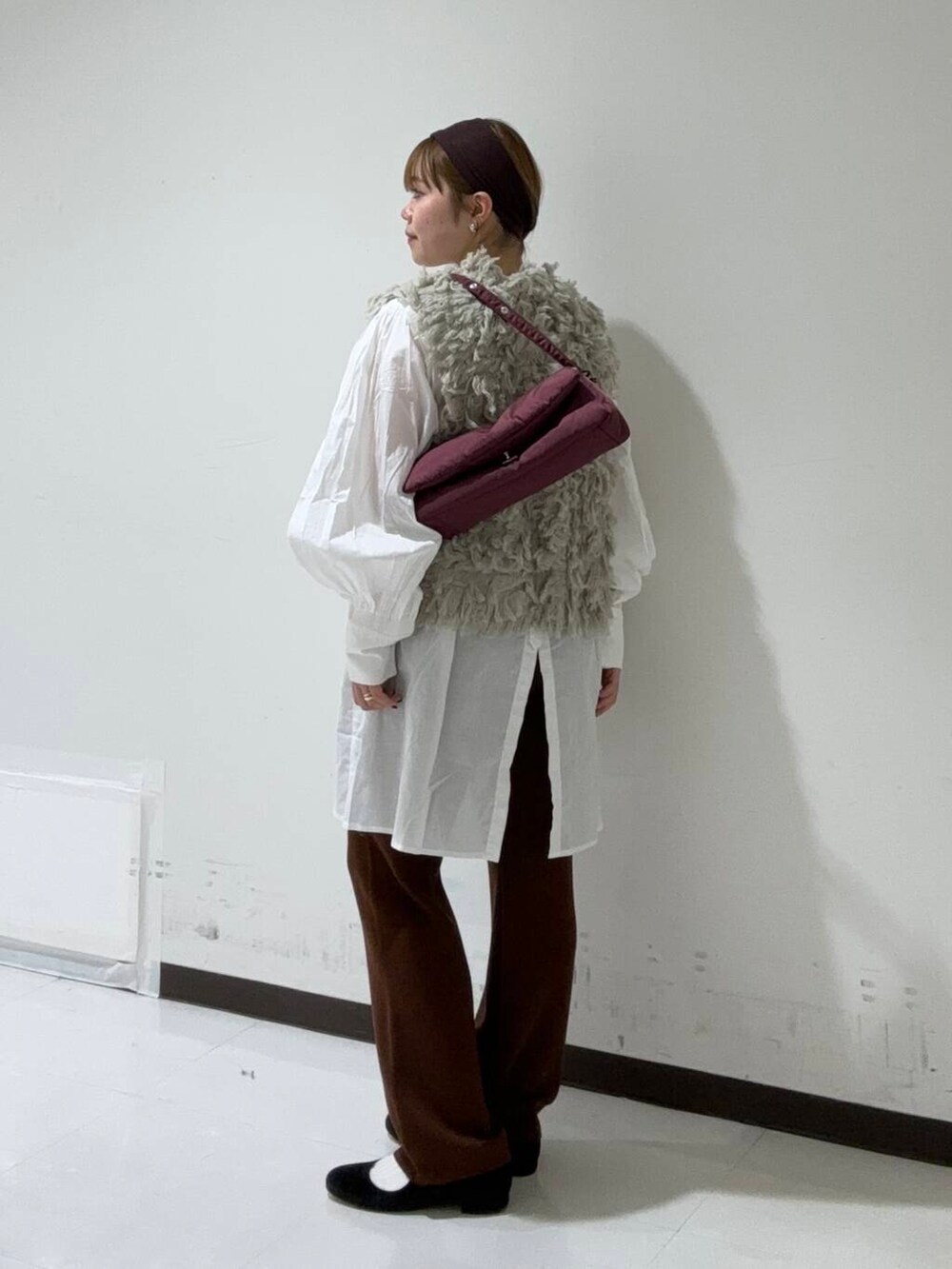 ブラウン系のその他パンツ、グレー系のベスト、レッド系のハンドバッグを着用したレディースの秋コーディネートの3枚目の写真