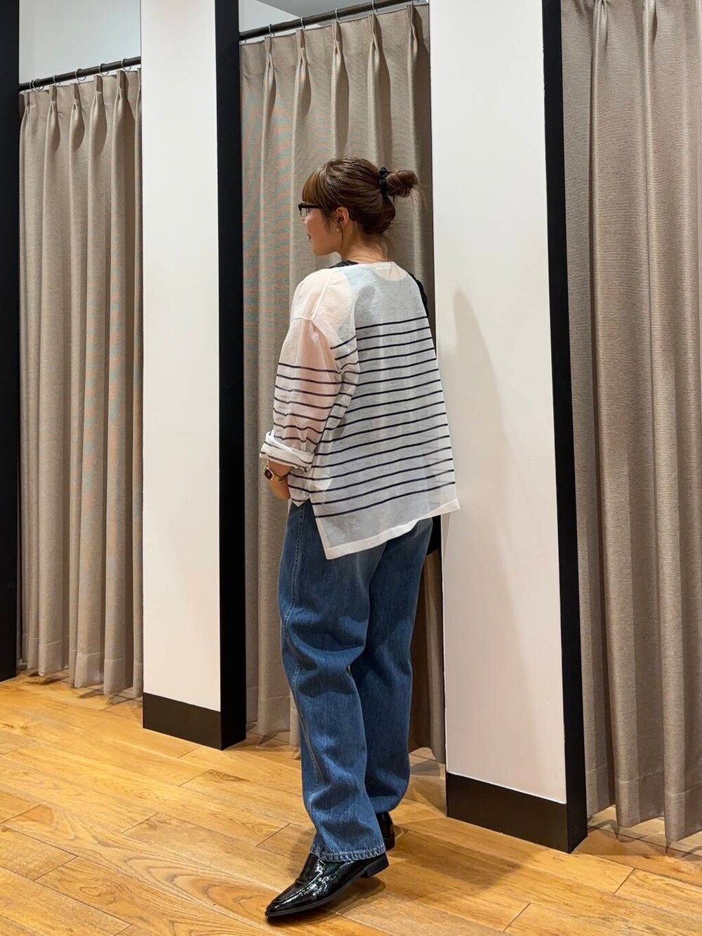 ブラック系のショルダーバッグ、ブラック系のローファー、ブルー系のデニムパンツを着用したレディースの夏コーディネートの2枚目の写真