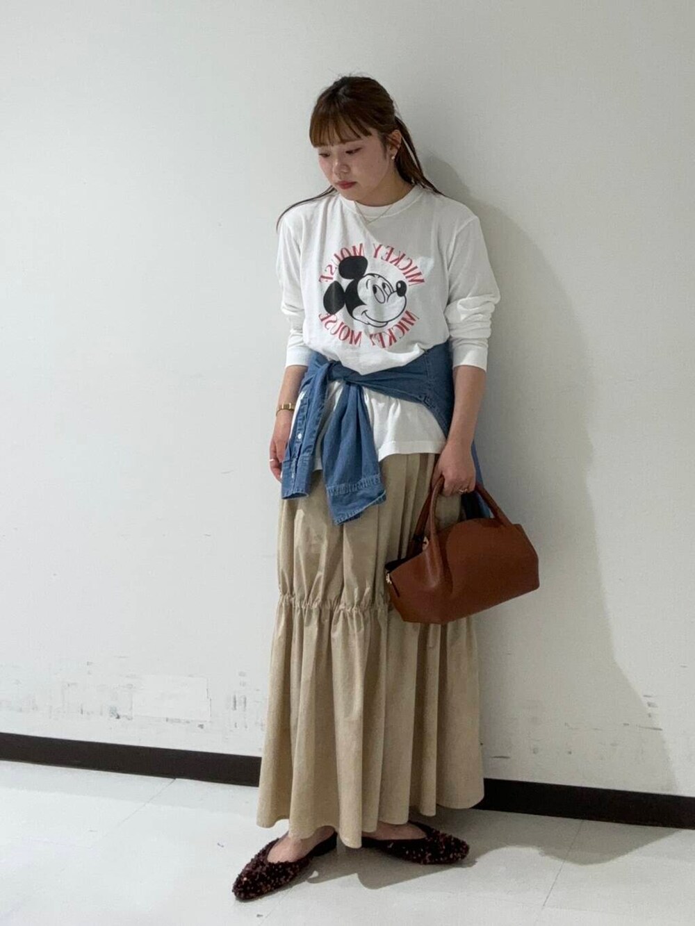 ブラウン系のその他シューズ、ブルー系のTシャツ/カットソー、ブラウン系のショルダーバッグを着用したレディースの秋コーディネートの2枚目の写真