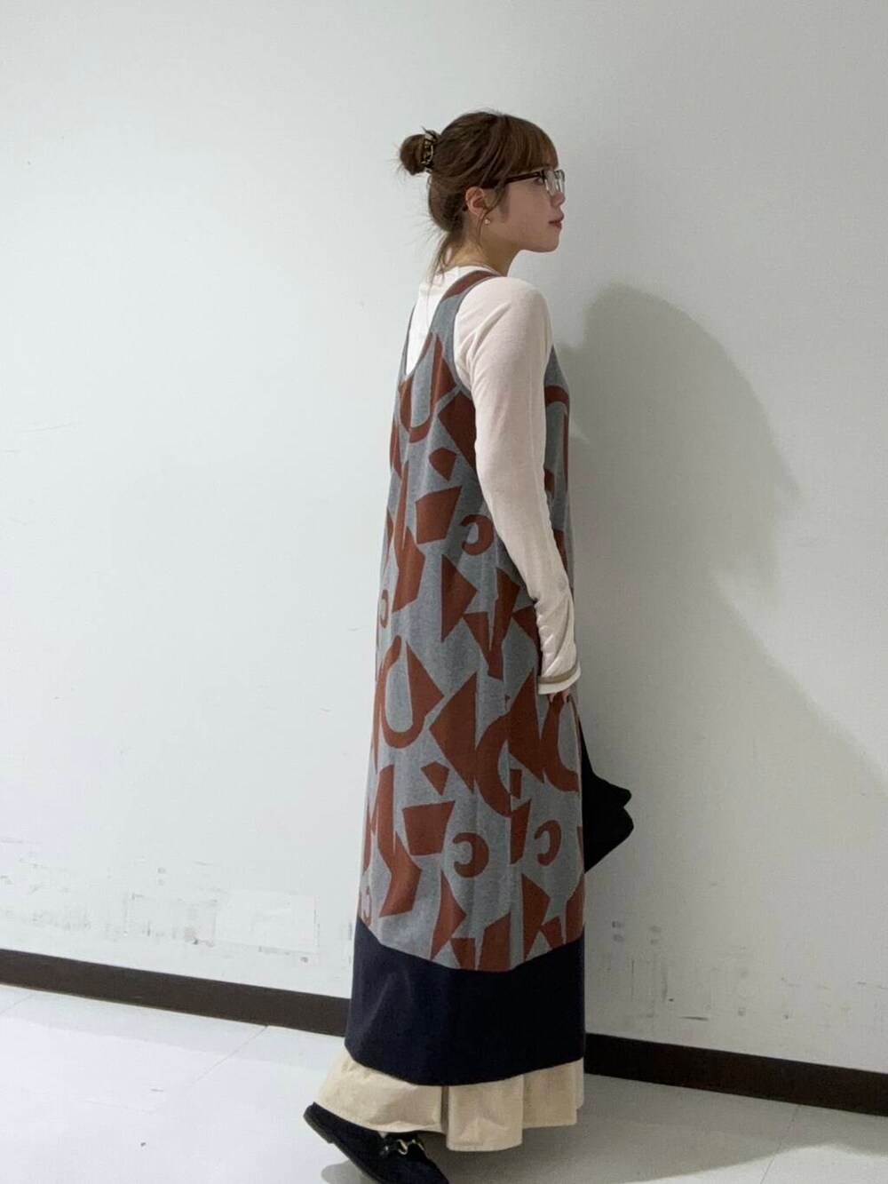 グレー系のTシャツ/カットソー、グレー系のニット/セーター、ブラック系のハンドバッグを着用したレディースの秋コーディネートの2枚目の写真