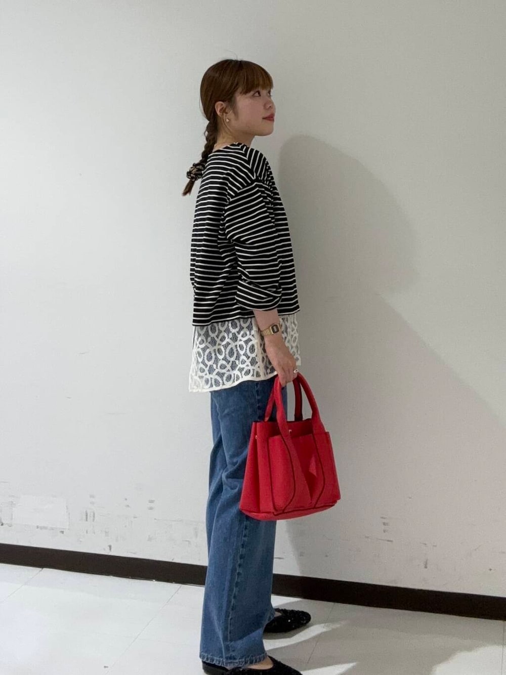 ブラック系のその他シューズ、ブルー系のデニムパンツ、レッド系のトートバッグを着用したレディースの夏コーディネートの2枚目の写真